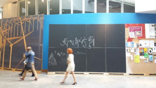 OM MANI PADME HUM written in chalk on 20 foot x 20 foot chalk board in Sata center lobby